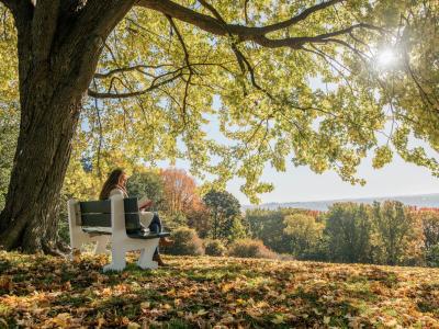 Girl sitting on a bench on the Plains of Abraham in autumn