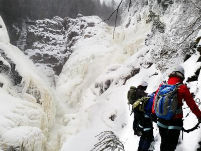 A group of people do the winter Via Ferrata activity at Canyon Sainte-Anne.