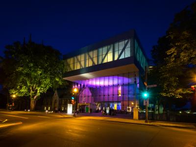 Exterior view of the illuminated Pierre Lassonde Pavilion at the Musée national des beaux-arts du Québec in the evening, in summer.