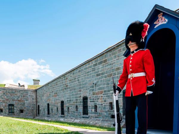 A guard dressed in the traditional uniform in front of the entrance door to the Citadelle of Québec.