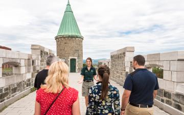Un groupe de visiteurs participent à un tour guidé à pied du Lieu historique national des Fortifications-de-Québec.