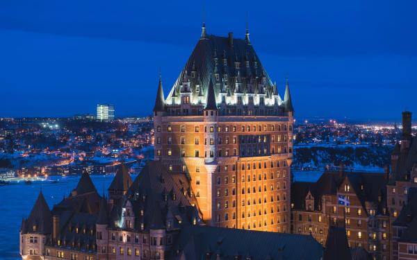 Aerial view of the illuminated Fairmont Le Château Frontenac in the evening, in winter.