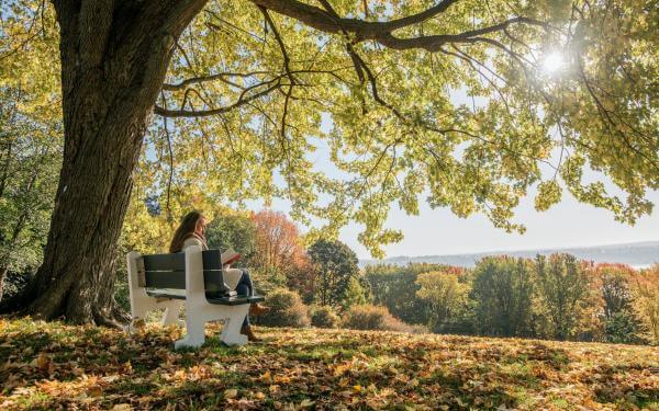 Girl sitting on a bench on the Plains of Abraham in autumn