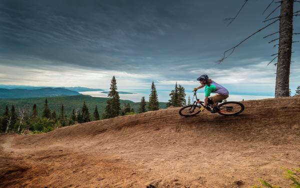 A cyclist enjoys the trails and the beautiful view on a mountain bike in the Massif de Charlevoix.