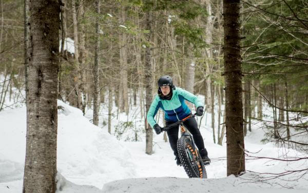 A person fatbikes on the bike trails at Mont-Sainte-Anne, in winter.