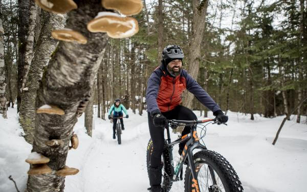 Outdoor enthusiasts ride fatbikes at Mont-Sainte-Anne.