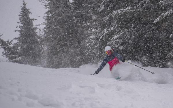 Une personne fait du ski alpin dans la neige poudreuse au Mont-Sainte-Anne.