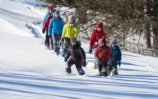 Family snowshoe hike on the snowy trails of the Station touristique Duchesnay.