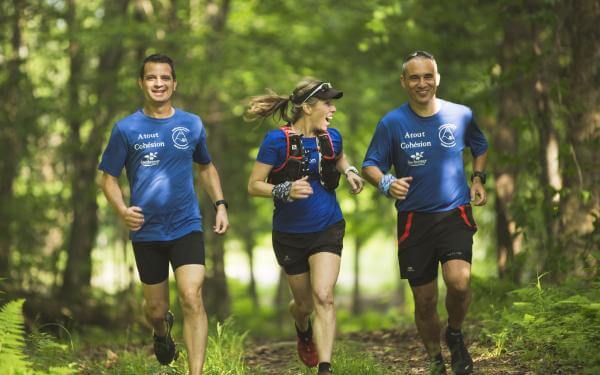 Three friends run in the forest on the trails of Station touristique Duchesnay.