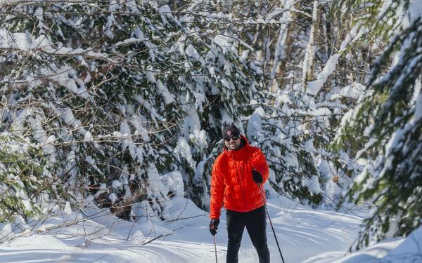 Un skieur fait du ski de fond dans un sentier enneigé dans la Réserve faunique de Portneuf.