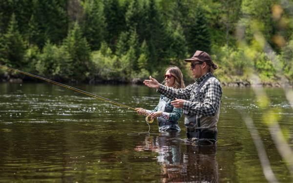 A couple fly fishing in the river in Jacques-Cartier National Park.