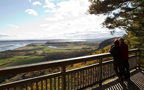 A couple contemplate the fall landscape from an observation point in the Cap-Tourmente National Wildlife Area.