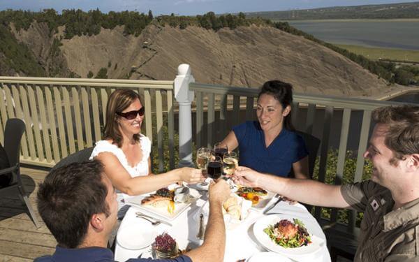 Des personnes mangent un repas sur la terrasse du Manoir Montmorency, situé sur le site du Parc de la Chute-Montmorency.