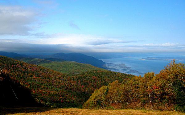 Les couleurs d'automne et le fleuve Saint-Laurent vus à partir du sommet d'une montagne au Massif de Charlevoix.