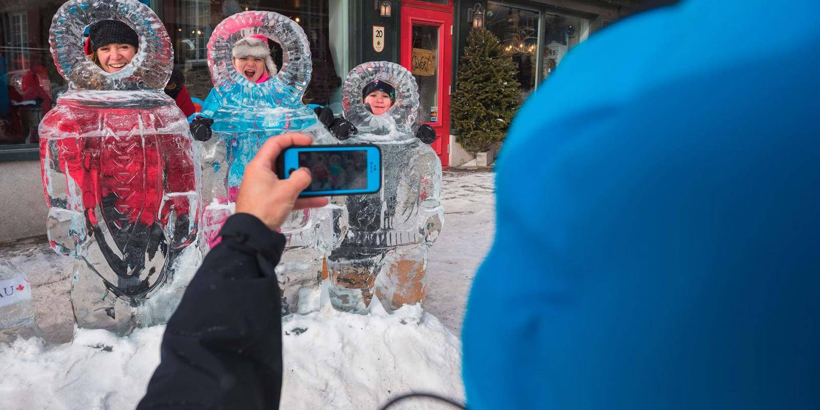 A family takes pictures with the ice sculptures in the Petit-Champlain district, during the Québec Winter Carnival.