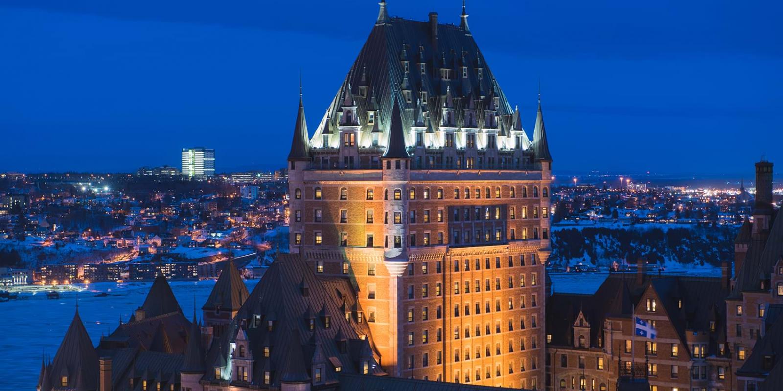 Aerial view of the illuminated Fairmont Le Château Frontenac in the evening, in winter.
