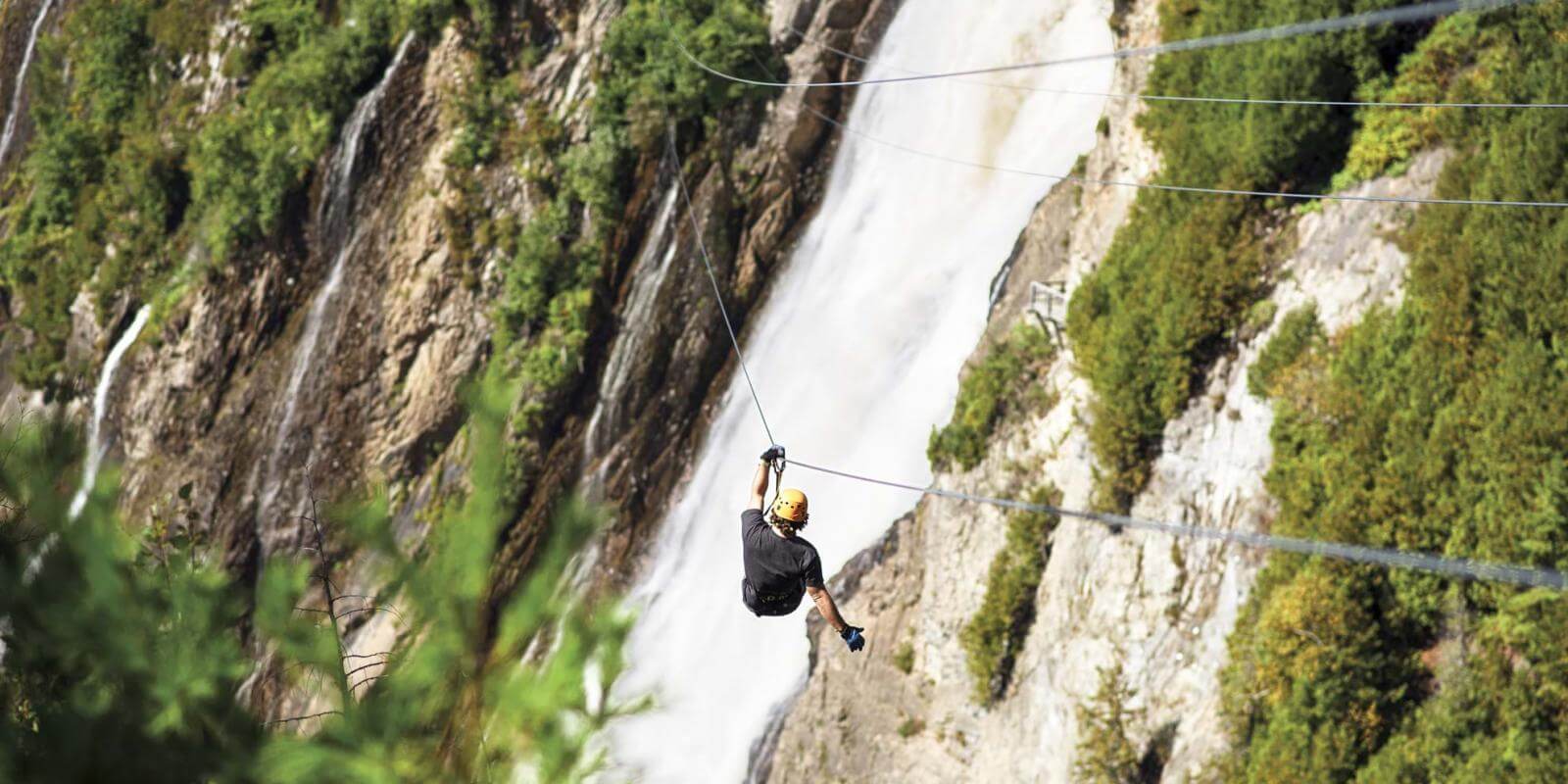 A man crosses the cove of the fall on a zip line at Parc de la Chute Montmorency.