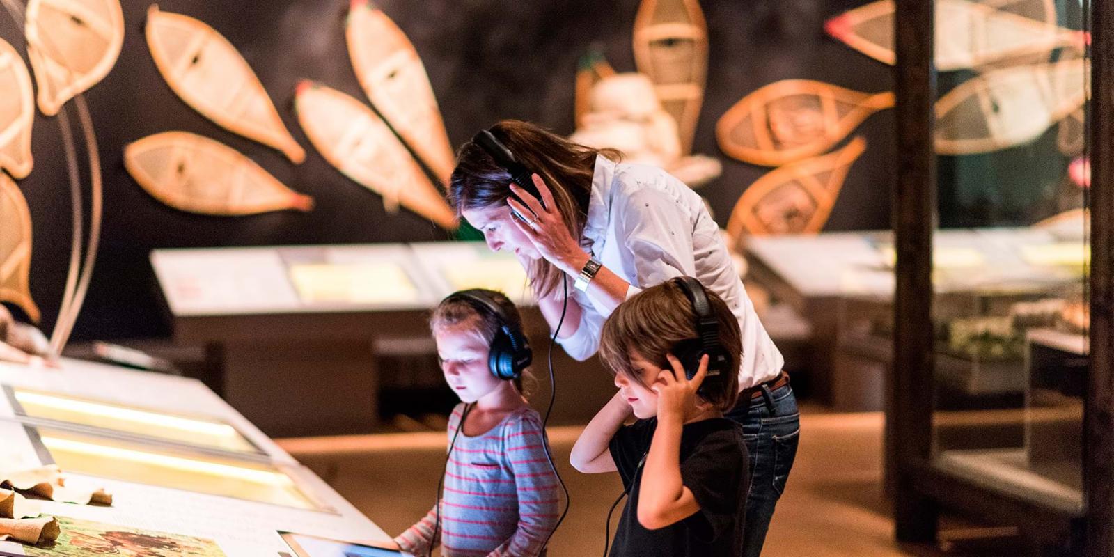 Une mère et deux enfants participent à une exposition interactive au Musée de la civilisation.