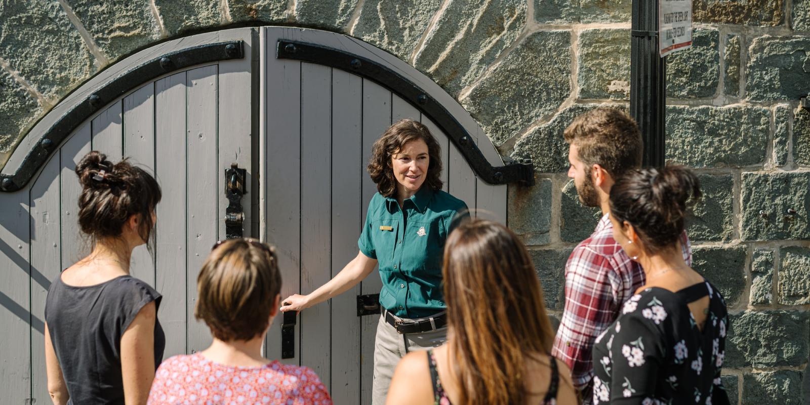 Un guide touristique avec un groupe de visiteurs devant les fortifications 