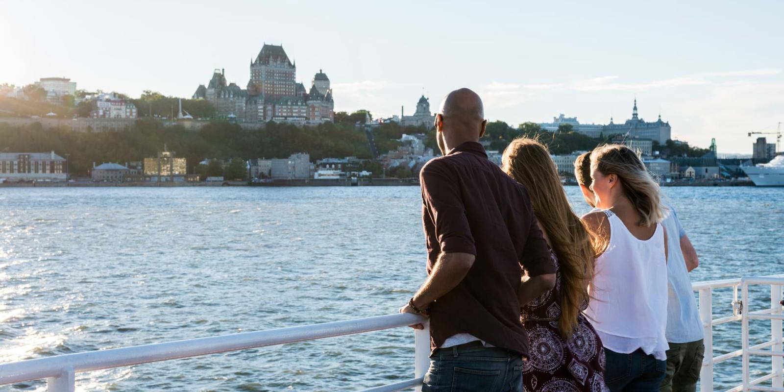 Groupe d'amis à bord du traversier Québec-Lévis, admirant le Vieux-Québec en été.