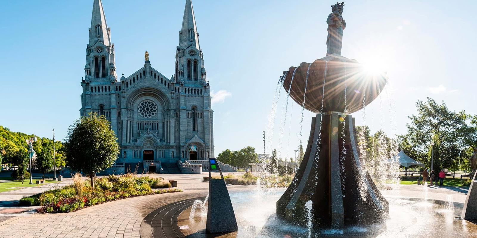 The exterior facade of the Sanctuary of Sainte-Anne-de-Beaupré with the fountain of Saint Anne in front of the basilica.