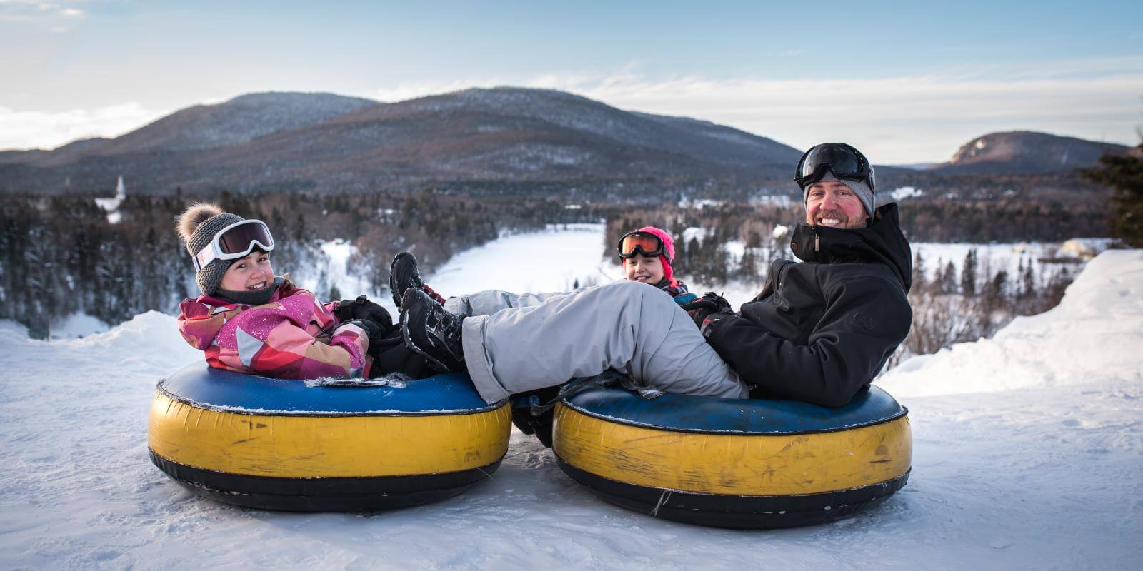 A family is getting ready to slide on inner tubes at Village Vacances Valcartier in winter.