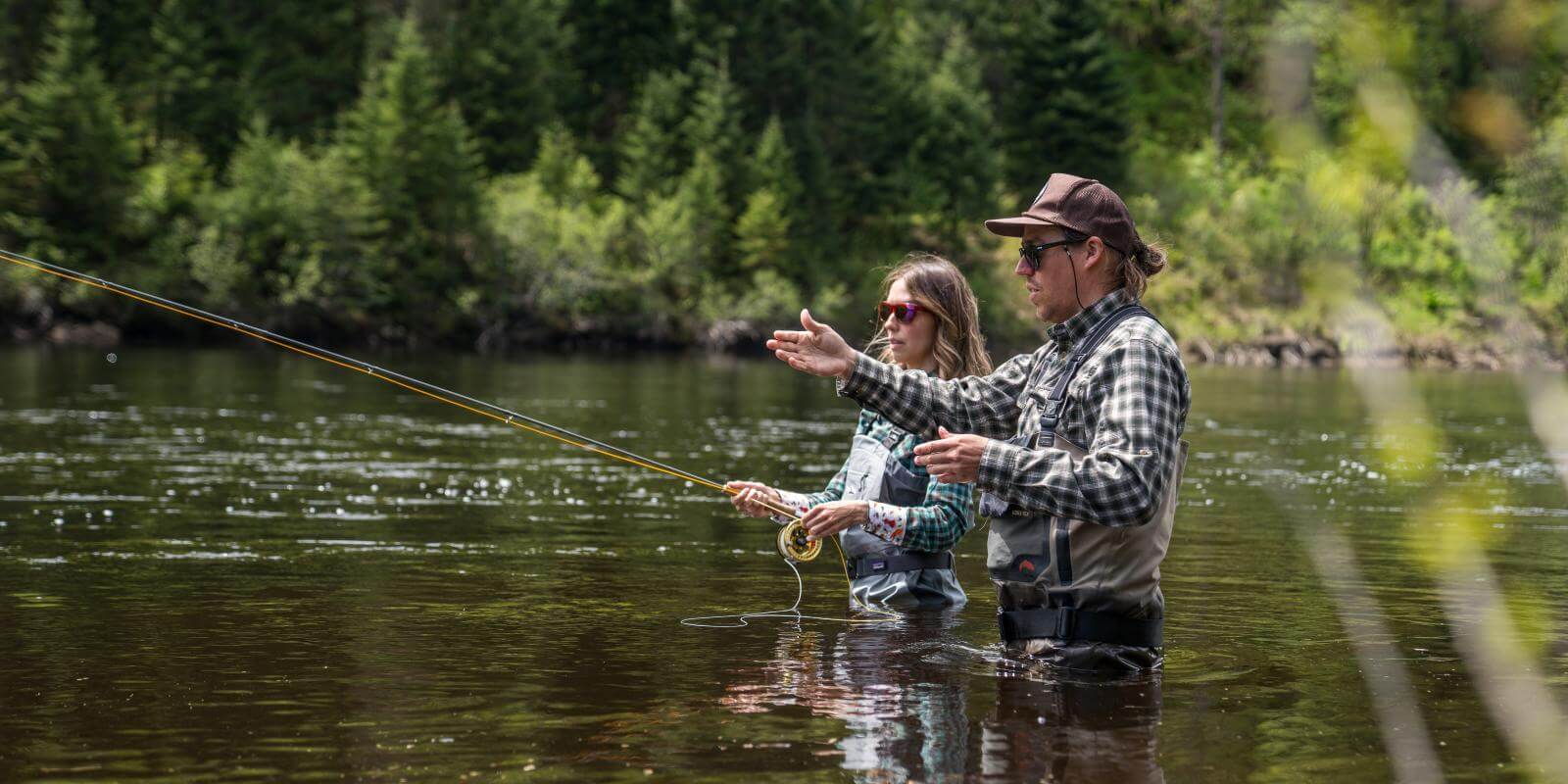 A couple fly fishing in the river in Jacques-Cartier National Park.