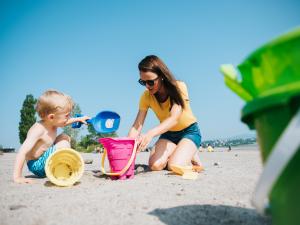 Une mère et son enfant jouent à construire un château de sable à la plage de la Baie de Beauport.
