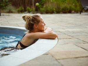 Une femme relaxe dans un spa extérieur au Aroma Spa du Village Vacances Valcartier.