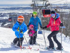 A family goes downhill skiing at Mont-Sainte-Anne.