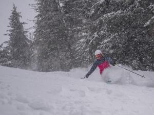 A person is downhill skiing in powder snow at Mont-Sainte-Anne.