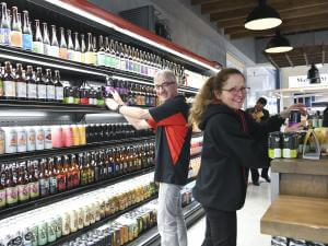 Des personnes sont près d'un réfrigérateur de bières au Grand Marché de Québec.