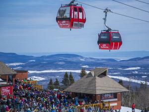 A crowd of people at the top of the mountain at the Mont-Sainte-Anne ski center.