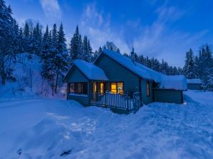 Exterior view of a chalet in winter, in the snowy forest of the Portneuf Wildlife Reserve.