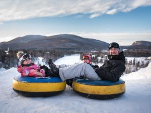 A family is getting ready to slide on inner tubes at Village Vacances Valcartier in winter.
