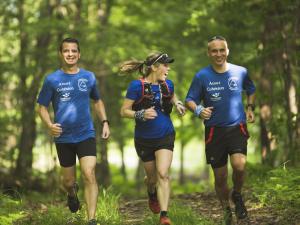 Trois amis font de la course en forêt dans les sentiers de la Station touristique Duchesnay.