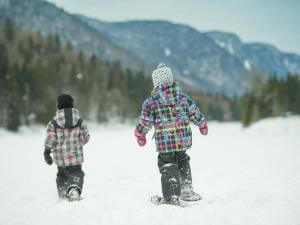 Deux enfants en raquettes dans le Parc national de la Jacques-Cartier, en hiver.
