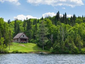 A chalet in the forest and on the edge of a lake in the Portneuf Wildlife Reserve.