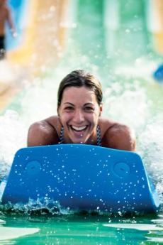 Une femme glisse dans la glissade d'eau Turbo 6 au Village Vacances Valcartier, en été.