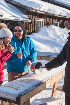 Maple taffy served to a couple at the sugar shack
