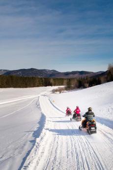 Snowmobilers riding in a field