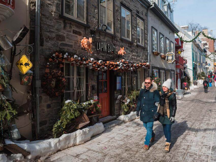 A couple walk in the street rue du Petit-Champlain, in winter.