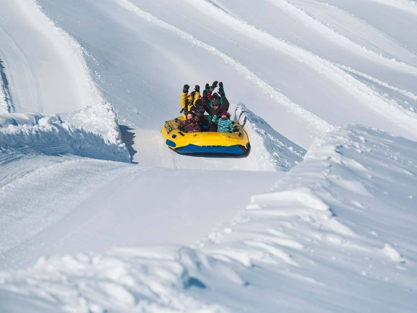 Des personnes font du rafting sur neige dans une glissade du Village Vacances Valcartier.