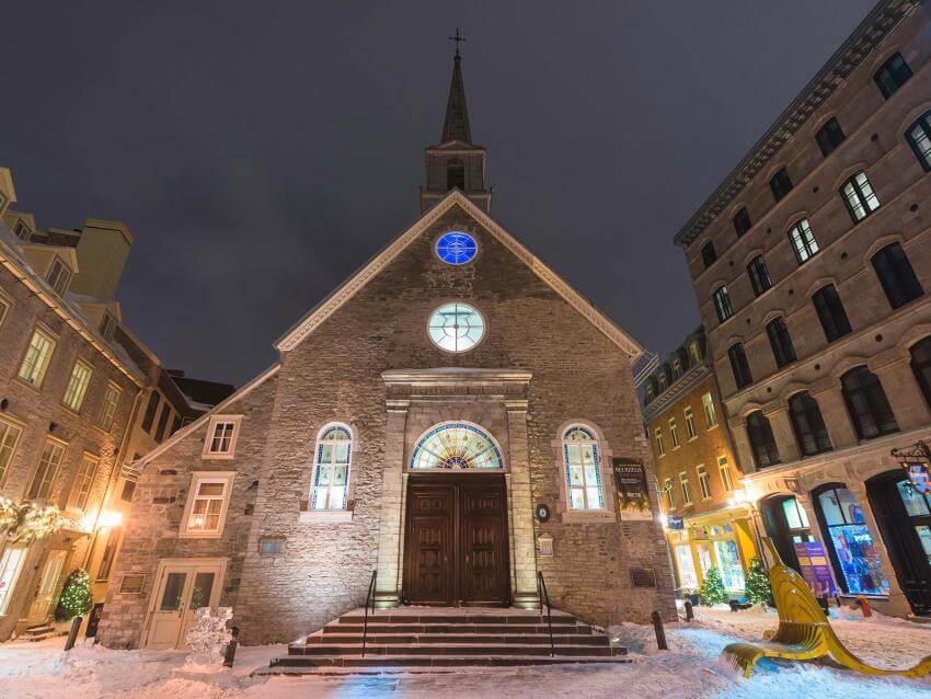 L'église Notre-Dame-des-Victoires illuminée en soirée, à Place-Royale, dans le quartier Petit-Champlain, en hiver.