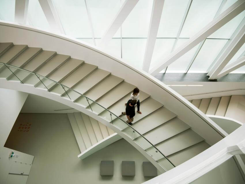 A couple descends the interior staircase of the Pierre Lassonde pavilion at the Musée national des beaux-arts du Québec.