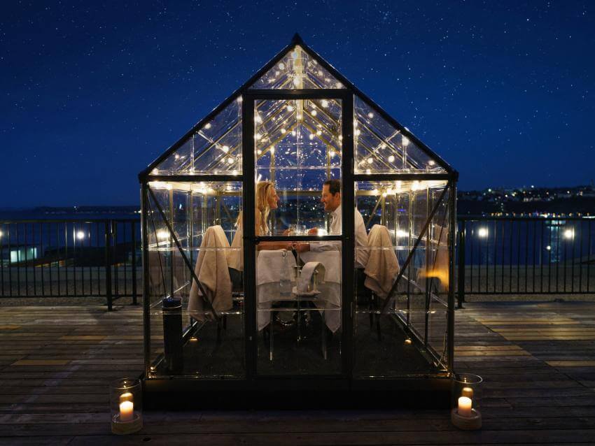 Couple qui mange dans une serre sous les étoiles sur le balcon de leur chambre à l'Auberge Saint-Antoine