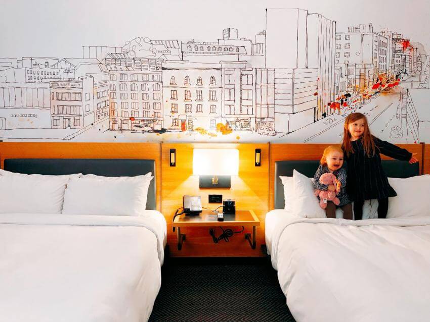 Deux enfants sur un lit d'une chambre d'hôtel