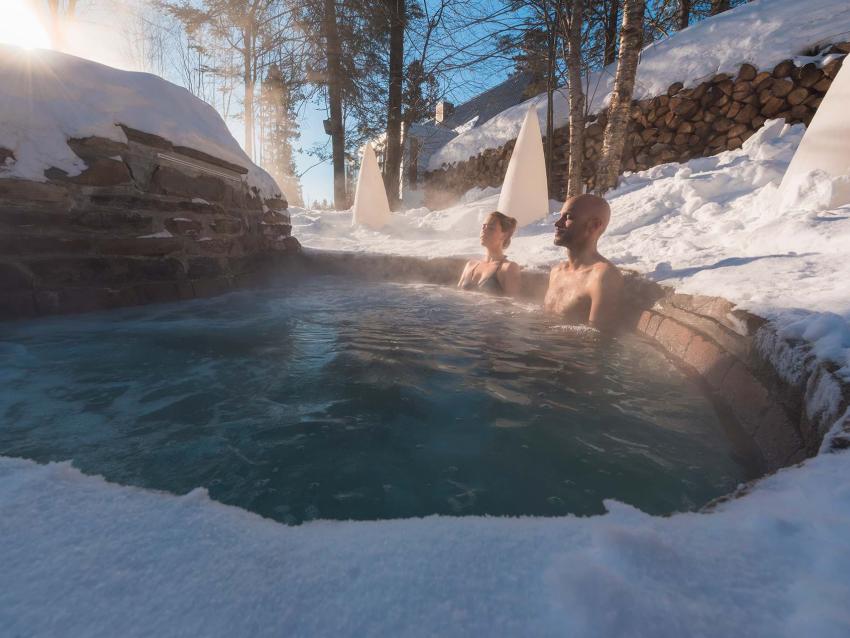 Un couple relaxe dans un spa nordique, en hiver.