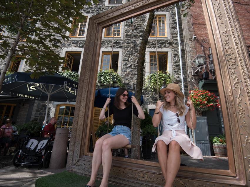 Deux filles se balancent sur une balançoire extérieure en été dans le quartier Petit-Champlain.
