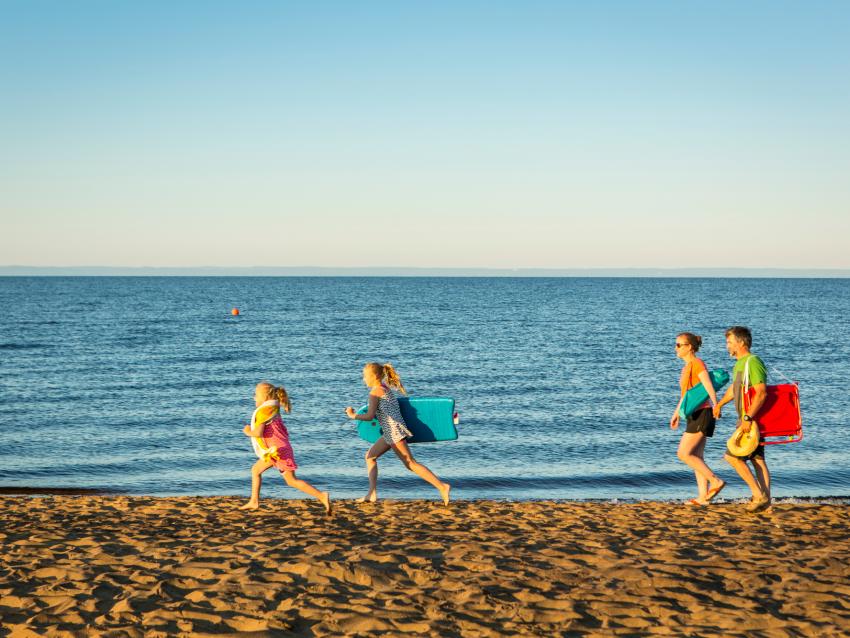 Famille qui marche sur la plage au parc national de la Pointe-Taillon 